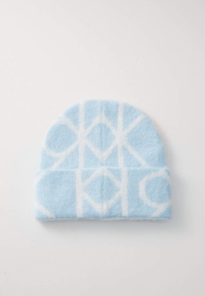 Bonnet en tricot bleu avec un motif géométrique blanc. Texture douce, sommet arrondi et design à revers.