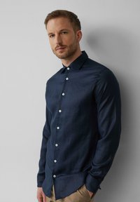 Navyblauw overhemd met lange mouwen van linnenstof, met een knoopsluiting aan de voorkant, een puntige kraag en witte knopen, in een slanke, getailleerde pasvorm.