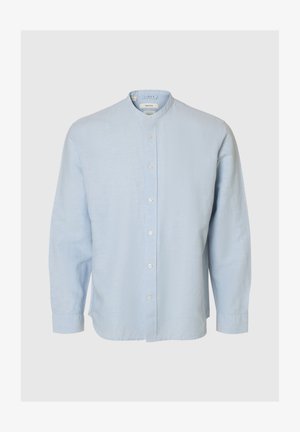 Gaiši zila lina krekls ar garām piedurknēm, mandarīnu apkakli un baltām pogām priekšpusē vienkāršā fonā.