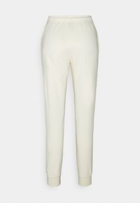 Cream-colored joggers made of soft fabric, featuring an elastic waistband and cuffs, smooth texture, and side pockets for functionality.
