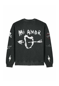 Sweatshirt noir avec le texte "Mi Amor", des graphismes de cœur et de flèche, des motifs de tête de mort et de cœur, et des accents d'éclairs sur les manches.