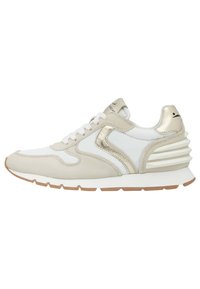 Beige und weiße Sneakers mit einem strukturierten Obermaterial aus Wildleder, glänzenden goldenen Akzenten, weißen Schnürsenkeln und einer mehrschichtigen Sohle für zusätzliche Unterstützung.