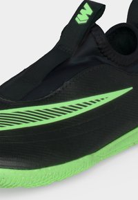 Μαύρο αθλητικό παπούτσι τύπου slip-on με φωτεινή νεον πράσινη σόλα, μεγάλο σχέδιο swoosh στο πλάι και ταινία με λογότυπο στον αστράγαλο.