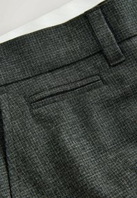 Charcoal gray trousers with a textured fabric, featuring a straight leg, a single back pocket, and a subtle pattern. Waistband is white.