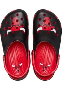 Sabots noirs et rouges avec un design perforé. L'avant présente un logo graphique. L'intérieur est rouge avec des motifs texturés. Brides de talon ajustables.