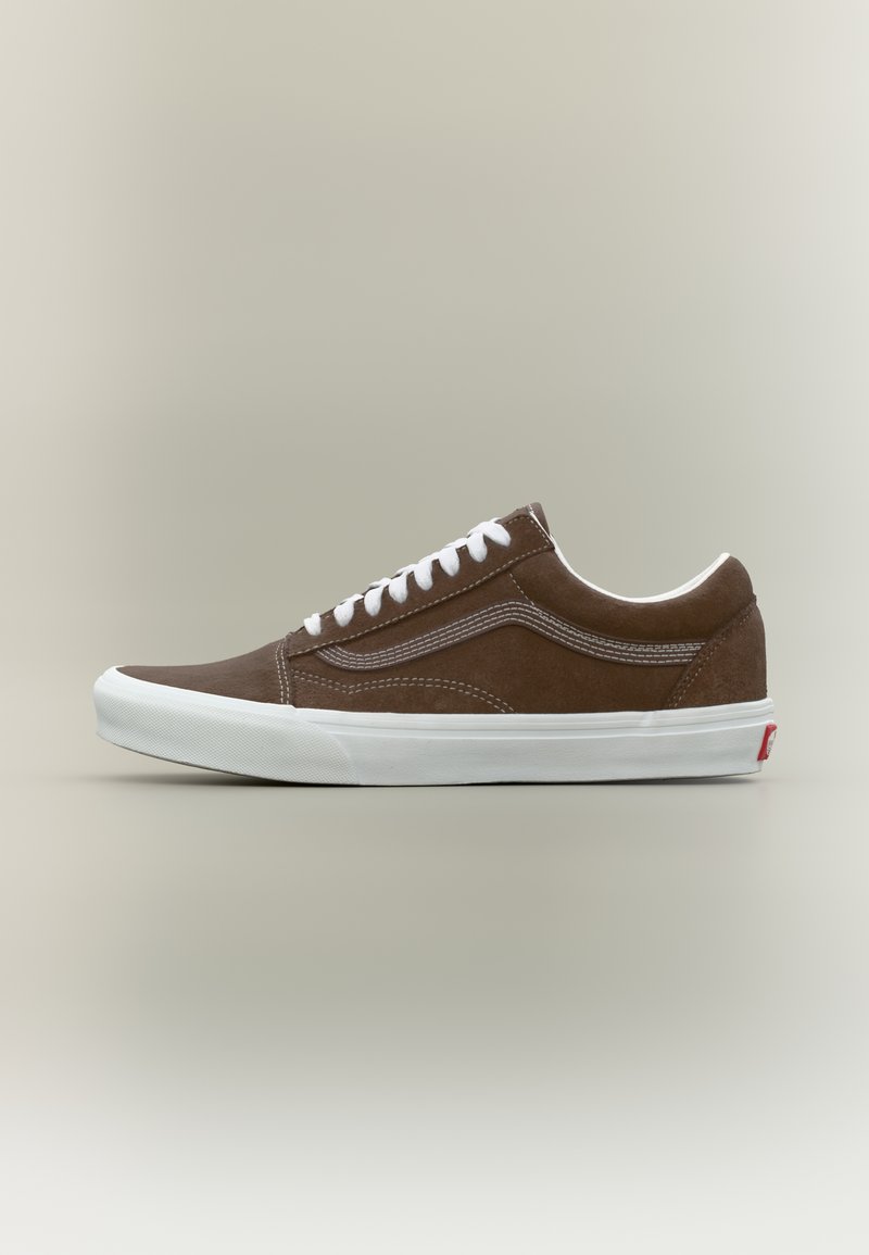 Καφέ χαμηλό δερμάτινο αθλητικό παπούτσι από καστόρι με λευκά κορδόνια, λευκή ραφή και χοντρή λε υκή ρητίνινη σόλα σε ουδέτερο φόντο.