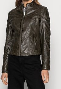 Brązowa skórzana kurtka motocyklowa z zamkiem z przodu, wysokim kołnierzem, bocznymi kieszeniami oraz detalicznym przeszyciem na ramionach i rękawach.