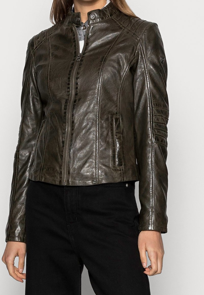 Brązowa skórzana kurtka motocyklowa z zamkiem z przodu, wysokim kołnierzem, bocznymi kieszeniami oraz detalicznym przeszyciem na ramionach i rękawach.