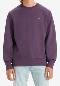 Sweat-shirt violet à col rond en tissu polaire, avec un petit logo Levi's rouge sur la poitrine, et des poignets et ourlet côtelés.