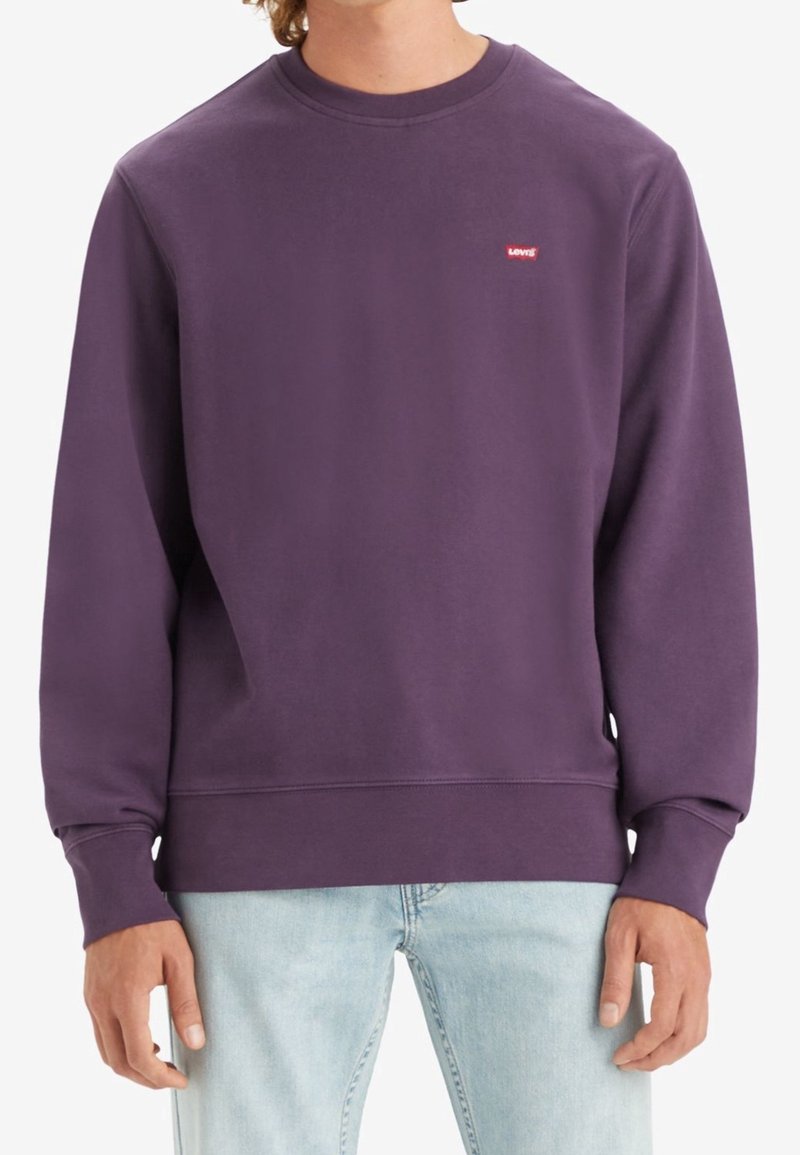 Sweat-shirt violet à col rond en tissu polaire, avec un petit logo Levi's rouge sur la poitrine, et des poignets et ourlet côtelés.