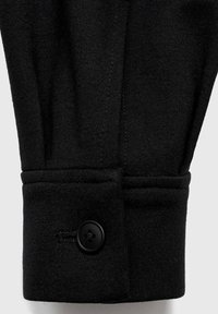 Black fabric cuff with a single black button and visible stitching. Smooth texture and structured design create a tailored appearance.