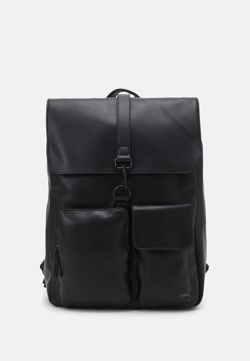 Sac à dos en cuir noir avec une fermeture à rabat, des bretelles réglables, une poche avant zippée et une poche plate sur le côté. Texture lisse.