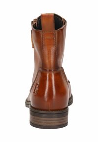 Braune Leder-Stiefelette mit glatter Oberfläche, runder Zehenpartie und niedrigem, gestapeltem Absatz. Hinterer Reißverschluss für einfaches An- und Ausziehen, strukturierte Sohle.