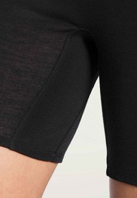 Black athletic shorts made of elastic fabric, featuring a smooth texture, fitted design, and a seam at the thigh for added comfort.