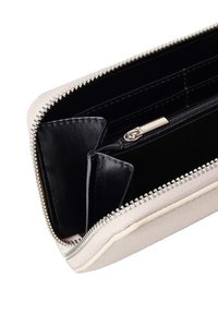 Portafoglio con zip in tessuto beige chiaro all'esterno e pelle nera all'interno, dotato di più slot per carte e di un vano con zip per le monete.