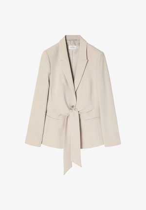Beige blézer puha anyagból, testhezálló fazonban, kivágott hajtókával, elülső gombbal és derékban megkötővel, valamint két oldalsó zsebbel.