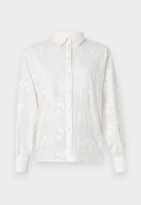 White long-sleeve button-up shirt featuring a textured floral embroidery pattern, pointed collar, and contrasting button placket.