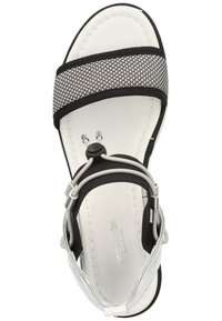 Black and white sandal featuring a textured upper strap, adjustable lacing, and a smooth, padded white insole with a rounded toe shape.