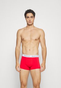 Rode boxershorts van katoen met een aansluitend ontwerp. Voorzien van een witte elastische tailleband met het "GANT" merklogo. Glad textuur.