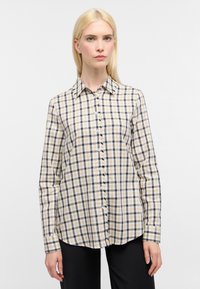 Camicia a quadri in beige, blu navy e bianco. Tessuto in cotone, colletto standard, maniche lunghe e orlo curvato. Presenta bottoni classici.