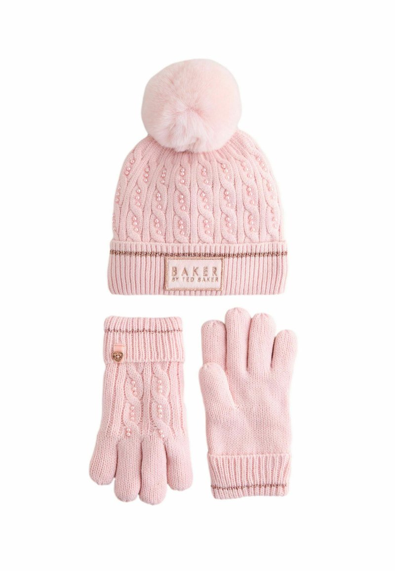 Hellrosa Strickmütze mit Pompon, Kabelmuster und einem dekorativen Etikett. Passende hellrosa gestrickte Handschuhe mit strukturiertem Design.