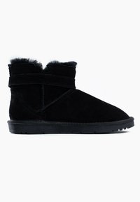 Botas de tobillo de ante negro con un suave collar de piel de animal, detalle de tira cruzada, punta redondeada y suela de goma texturizada con un perfil bajo.