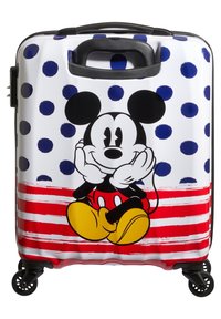 Valise rigide avec une surface blanche brillante ornée de pois navy, de rayures rouges et d'un graphique représentant un personnage de dessin animé souriant.