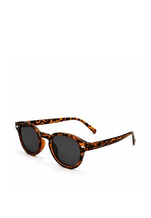 Lunettes de soleil à motif écaille avec verres ronds foncés et monture légère sur fond blanc.