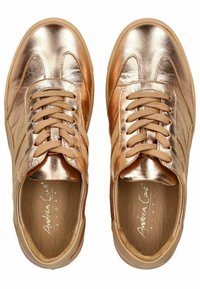 Sneakers rosa oro metallizzato con tomaia in pelle liscia, chiusura con lacci e dettagli beige, dotati di soletta imbottita e suola in gomma.