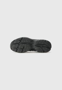 Black athletic shoe sole with a textured rubber surface, featuring a detailed tread pattern for traction and support.