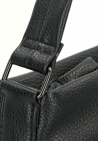 Schwarze Lederhandtasche mit strukturierter Oberfläche, ausgestattet mit einem flachen Riemen und Metallbeschlägen. Akzente sind ein gepolsterter Verbinder am Riemen.