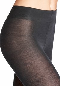 Collant neri con un elastico a coste in vita, texture semitrasparente, finitura liscia e leggero riflesso. La visione ravvicinata sull'area della gamba mostra un design senza cuciture.