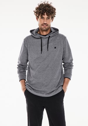 Sudadera gris de textura suave, con mangas largas y un bolsillo frontal. Presenta un cordón negro y un pequeño logo en el pecho.