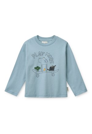 Chemise bleu clair à manches longues avec le texte "PLAY MORE" et un dessin animé représentant un arbre, un oiseau, un hippopotame et un éléphant sur un skateboard.