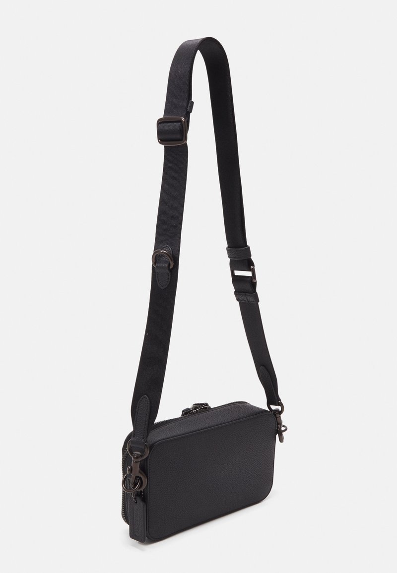 Schwarze, rechteckige Crossbody-Tasche aus texturiertem Material, ausgestattet mit einem verstellbaren Riemen und einem Reißverschluss. Akzente sind metallische Beschläge.