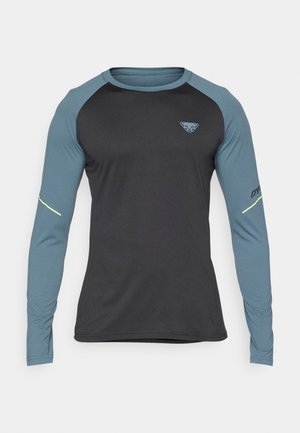 Ilga rankovė sportinė marškinė su juodu korpusu ir mėlynais raglanų rankovėmis. Yra mažas logotipas ant krūtinės ir atspindinčios detalės ant rankų.