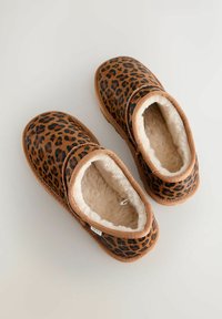 Zapatillas de leopardo con un suave forro de faux piel beige y ribete marrón. Diseño sin cordones, cómodo y con forma de punta redondeada.