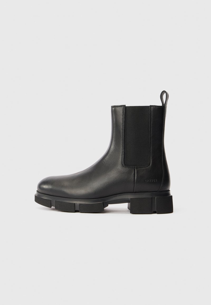 Musthave nahkaste Chelsea saapad paksu taldaga, elastse külgpaneeliga, taga tõmblukku ja brändi nimi reljeefselt kandmisel.