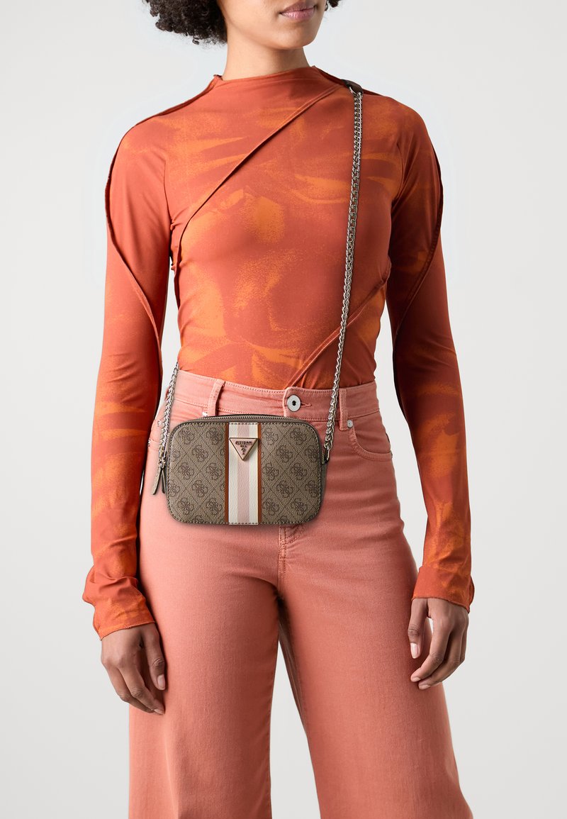 Brun mønstret taske med rektangulær form, der har en lys stribe og logo. Båret crossbody med en metal kædestrop.