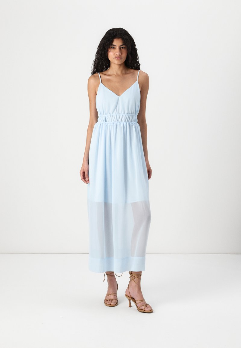 Ανοιχτό μπλε μακρύ φόρεμα με V-λαιμόκοψη, μαζεμένη μέση και διαφανή κάτω πάνελ. Ρυθμιζόμενοι λεπτοί ιμάντες; λείο υλικό.
