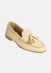 Beige Lederloafer mit Quasten-Detail, abgerundeter Spitze, niedrigem Holzabsatz und weicher Innenauskleidung. Glatte Textur und klassisches Design.