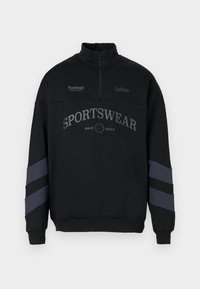 Felpa nera con collo a mezza zip, con la scritta "SPORTSWEAR" in grigio e dettagli a righe grigie sulle maniche. Realizzata in tessuto morbido.