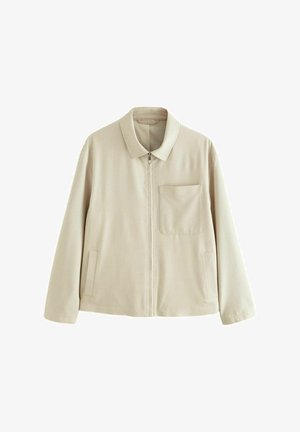 Beige színű, könnyű dzseki cipzáros elejével, strukturált gallérral, mellzsebbel és oldalzsebekkel. Simai textúrával és minimalista dizájnnal rendelkezik.