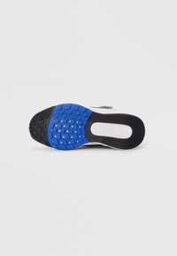 Zwarte en blauwe sportieve schoenzool met een textuur oppervlak, featuring een mix van ronde en hoekige grip patronen voor tractie.