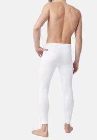 Pantalones legging blancos con una textura suave y una cinturilla elástica, que presentan costuras mínimas para un ajuste aerodinámico. Sin patrones o acentos visibles.