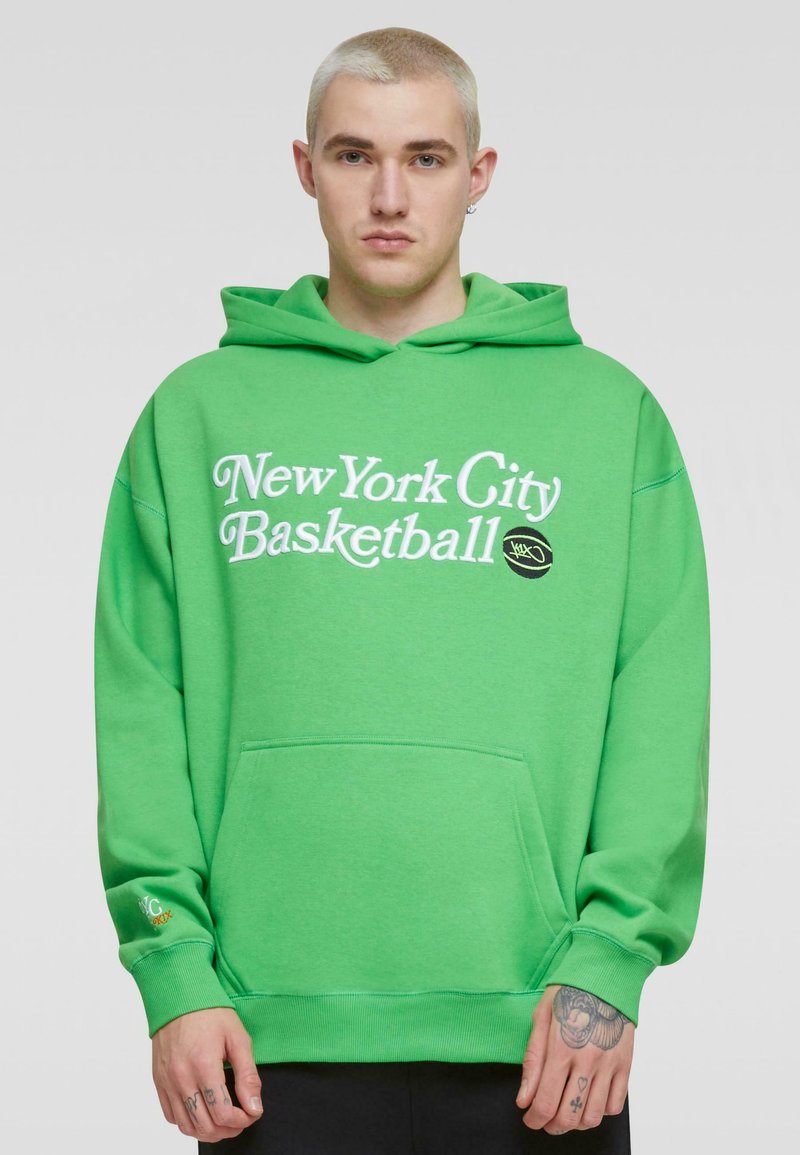 Felpa verde brillante con testo bianco "New York City Basketball", tasca a marsupio, polsini e orlo a costine. Materiale misto cotone, vestibilità casual.