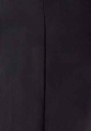 Dettaglio di un tessuto nero con una cucitura verticale e una texture di intreccio diagonale visibile.