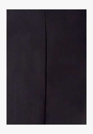 Dettaglio di un tessuto nero con una cucitura verticale e una texture di intreccio diagonale visibile.