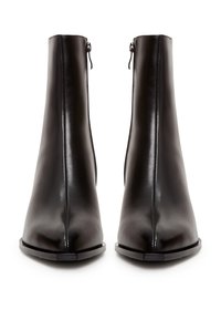 Paire de bottines en cuir noir avec fermetures éclair latérales, bouts carrés et semelles plates, vues de face sur fond blanc.