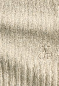 Maglione a maglia beige chiaro con texture a coste e leggere sfumature. Presenta un piccolo logo ricamato "MOP" in basso a destra.